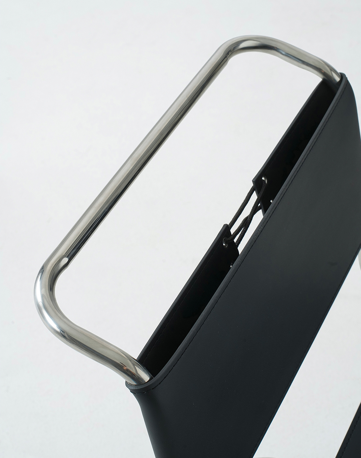 Close-up of a black chair backrest with a curved silver metal handle on a plain white background.