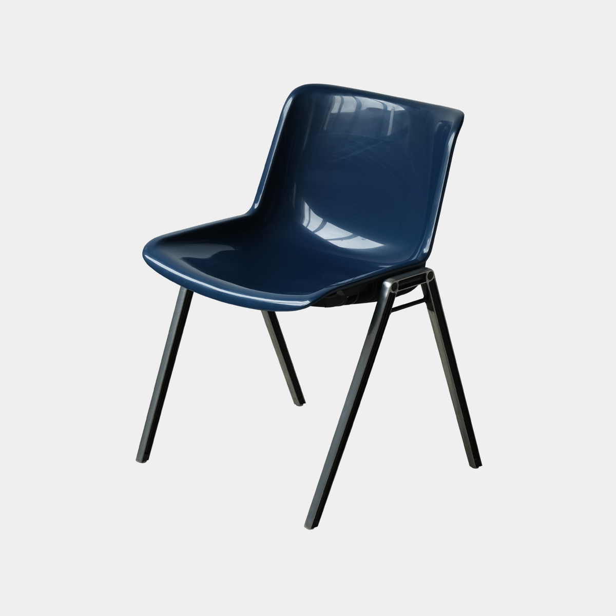 A modern molded plastic dining chair in dark blue with black metal legs, shown against a plain light gray background.