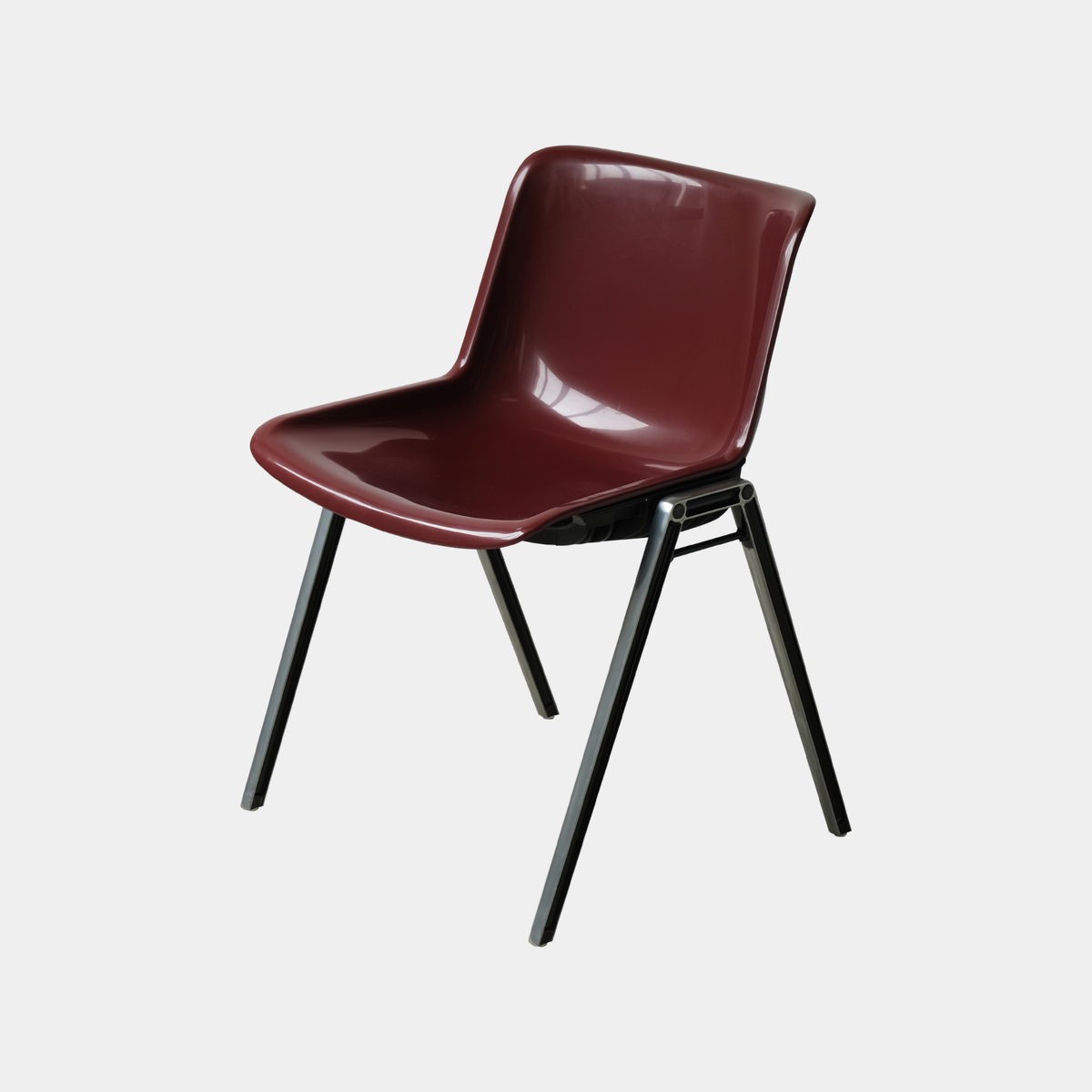 A modern molded plastic chair with a glossy dark red seat and backrest, supported by four black metal legs, shown against a plain light gray background.