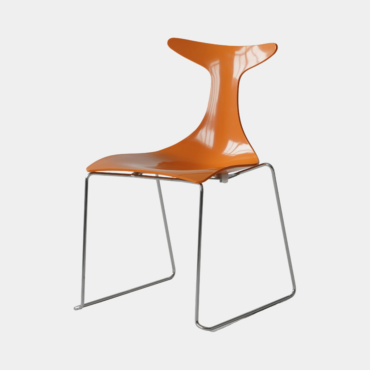 An orange molded plastic chair with a chrome metal wire frame, shown against a light gray background.